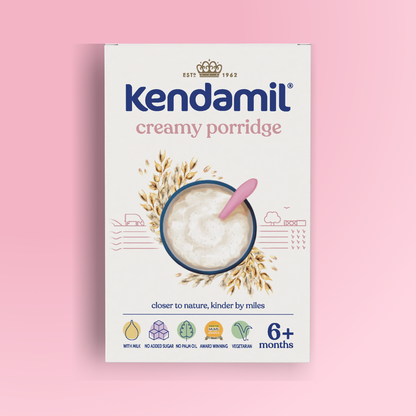 5-Pack Creamy Baby Porridge (6+ months) boxes displayed against a pink background, featuring an illustrated bowl of baby porridge with a pink spoon, oats, and icons indicating suitability for babies 6+ months, vegetarian-friendly ingredients, and no added sugar or palm oil.