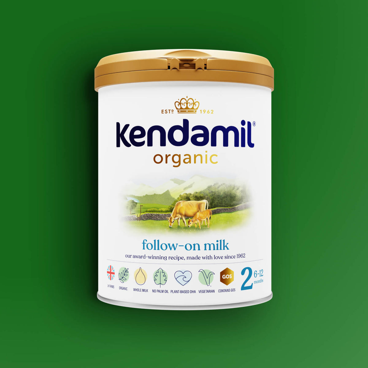 A can of Organic Follow-On Milk featuring a gold lid, cow illustration, and green landscape set against a green background. This organic formula is made from whole milk sourced from grass-fed cows and is suitable for babies aged 6-12 months.