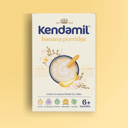 A box of Kendamil 7-Pack Banana Baby Porridge (6+ months), featuring banana porridge made with high quality grains, a bowl with a spoon, banana slices, and illustrated flowers on a light yellow background.