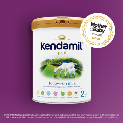 Goat Follow-On Milk tin displayed against a purple background, featuring two goats, prominent award badges, and a gold Mother & Baby Awards sticker. The bottom text provides breastfeeding guidance and emphasizes support for infant nutrition with whole A2 goat milk.
